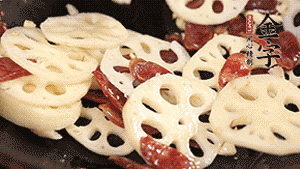 依次下香腸片、藕片翻炒均勻，加適量清水燜熟。