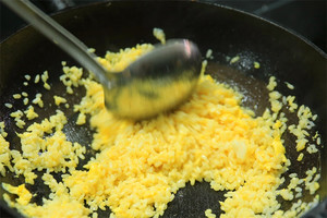 大火加熱炒鍋，再入油，燒到四至五成熱時(shí)倒入雞蛋液，在未凝結(jié)之前，加米飯煸炒，不停翻炒并用鍋鏟將成塊的米飯碾開、撥散。