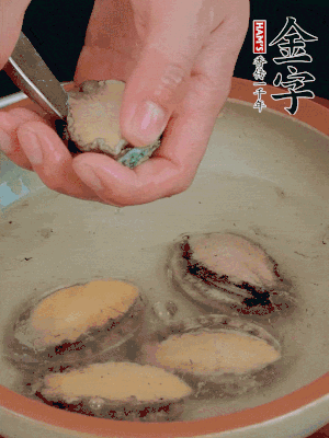 鮑魚加鹽、清水浸泡，用勺子挖出鮑魚肉。