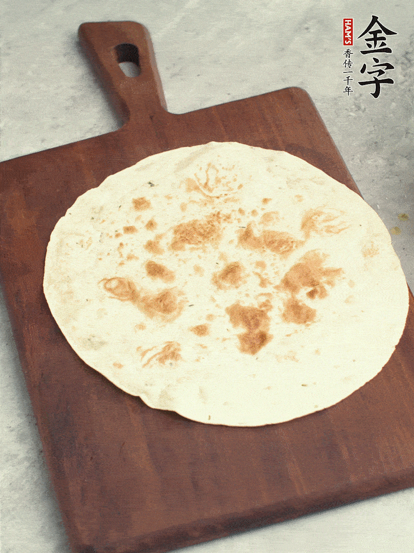 食材依次鋪在卷餅皮上，卷起來(lái)。