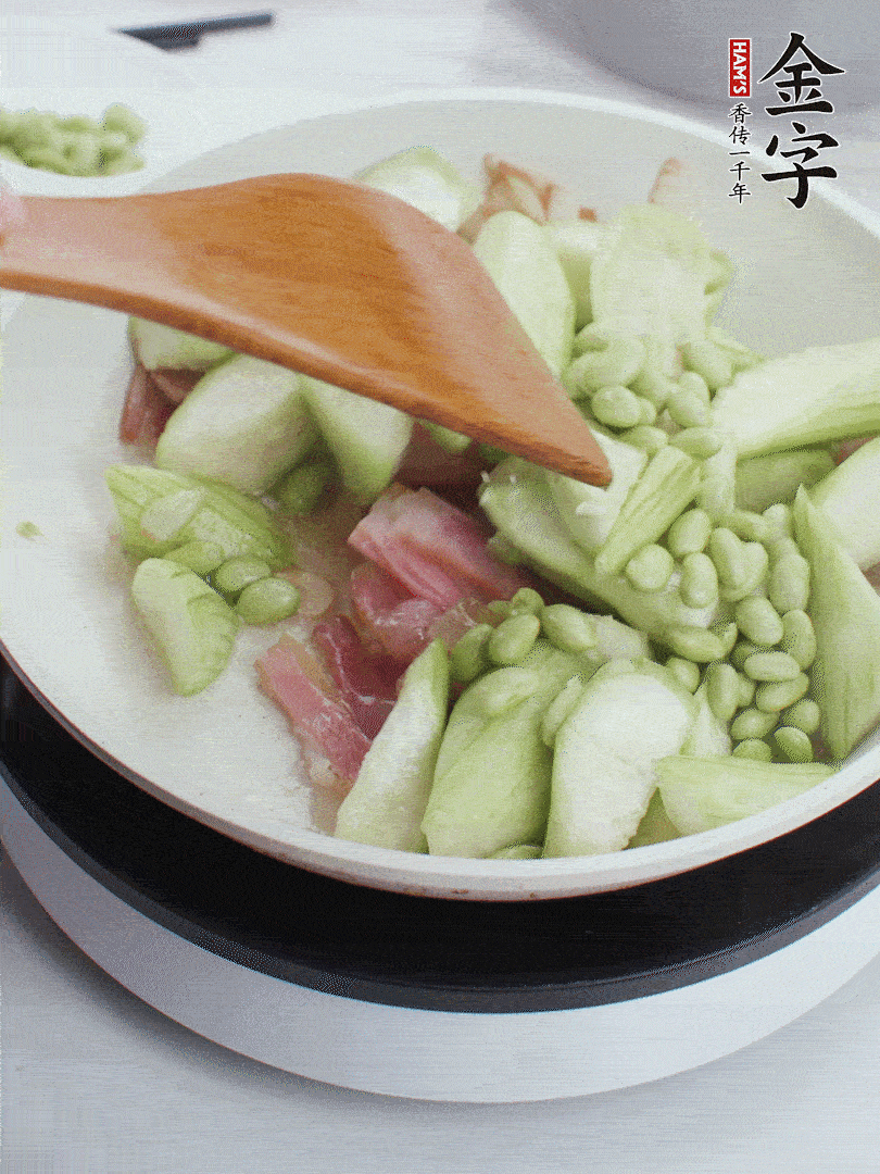 依次下絲瓜、青豆翻炒，炒至絲瓜打蔫縮小。
