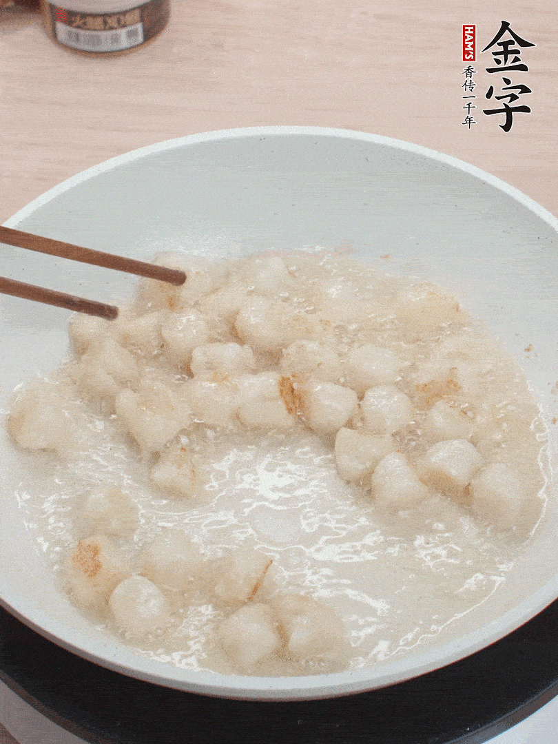 油溫4成熱，鮮貝蘸干淀粉下鍋煎，一面微黃后翻面。