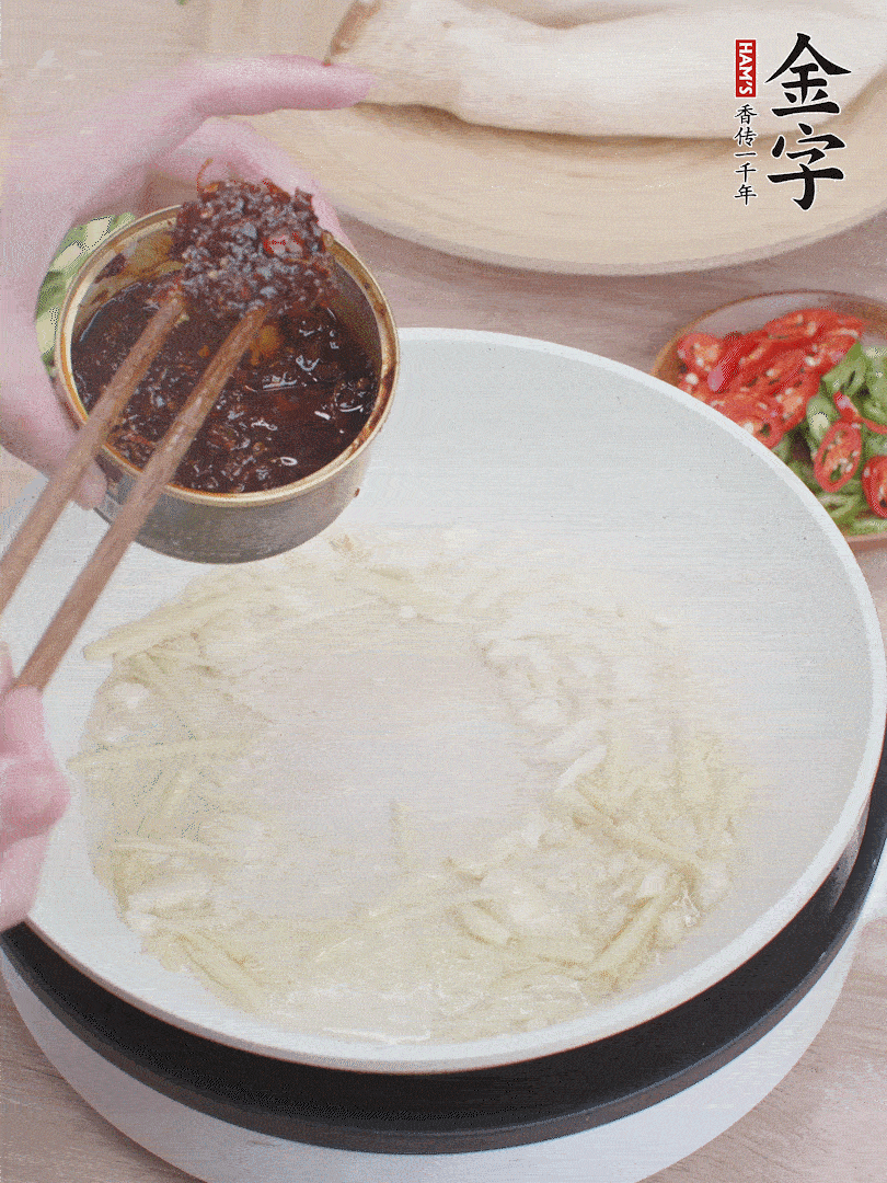 起鍋熱油，姜蒜、金字火腿干貝醬煸香。