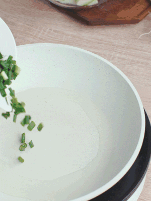 熱油下臘肉、蔥花煸炒，再下西葫蘆。