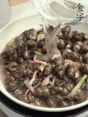 倒處理干凈的螺螄翻炒，加3勺料酒。加清水蓋過(guò)螺螄，中火蓋蓋煮5分鐘。