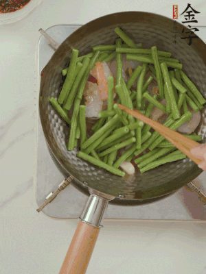 下掰好的缸豆段翻炒，略燜煮。