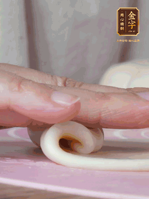 做面劑 油皮按扁，中間包入一個油酥，邊緣收緊捏死。包好的面劑按扁，用搟面杖搟壓成橢圓形。從底部向上卷成筒狀，用保鮮膜蓋好松弛15分鐘，再把筒狀縱向搟壓成長條狀。再卷一次，松弛20分鐘