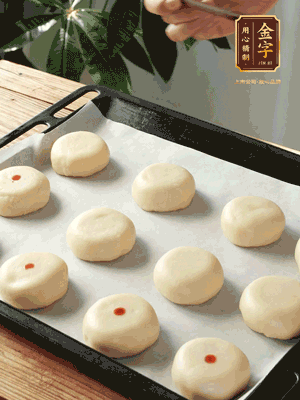 收口向下放在案板上，輕輕將月餅坯按扁，用筷子點紅點做裝飾