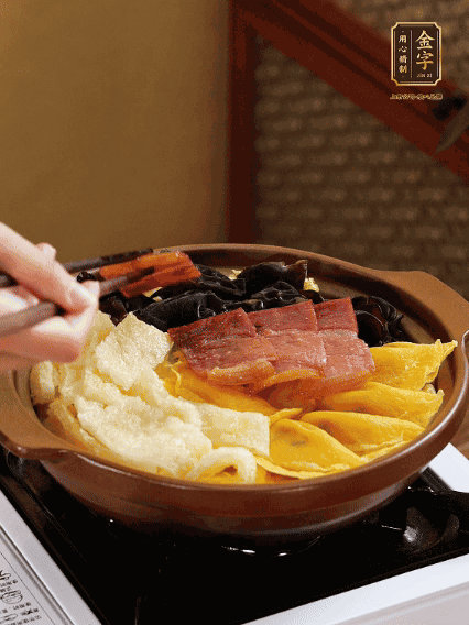 砂鍋底部鋪上娃娃菜，依次擺上肉皮、蛋餃、黑木耳、火腿